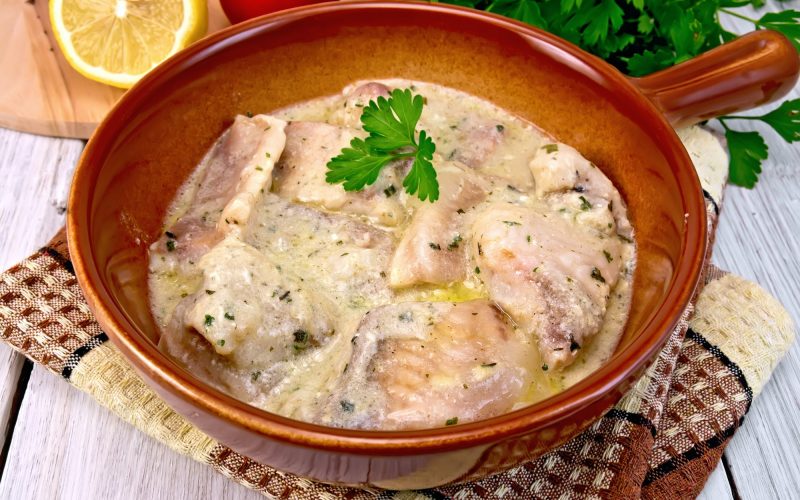 Fish stew in sauce on ceramic pan